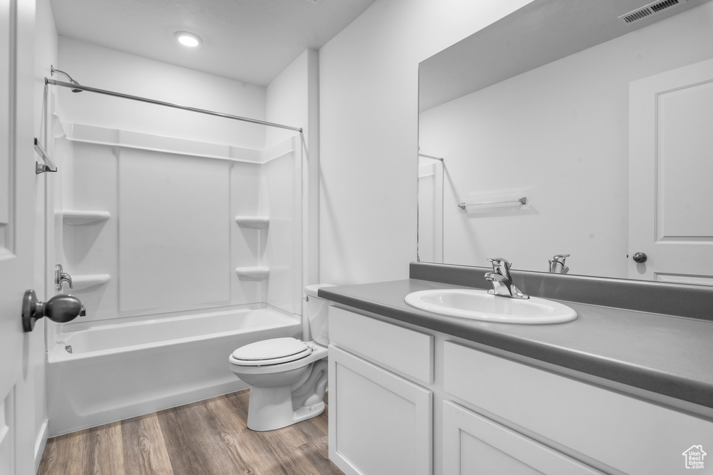 Full bathroom with shower / bath combination, vanity, toilet, and hardwood / wood-style flooring