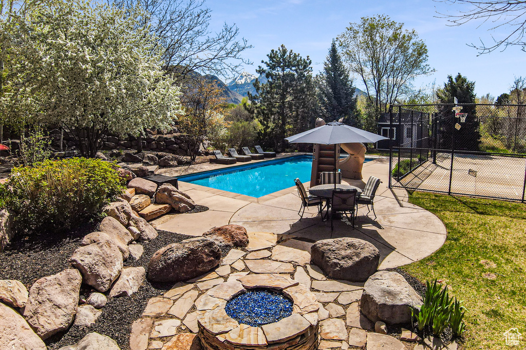 View of swimming pool featuring a patio, a fire pit, and a mountain view