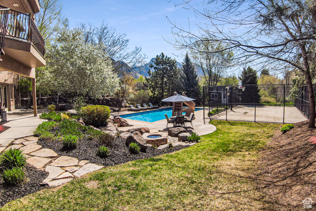 View of pool with a lawn, a mountain view, and a patio