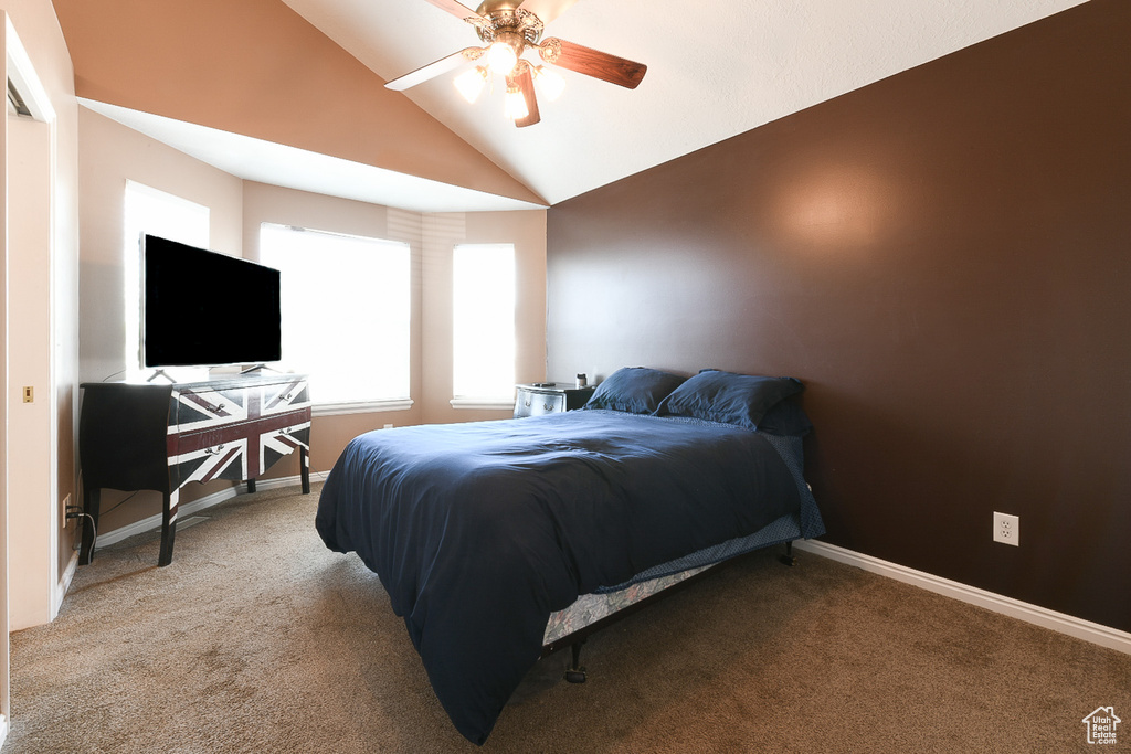 Carpeted bedroom featuring ceiling fan and lofted ceiling