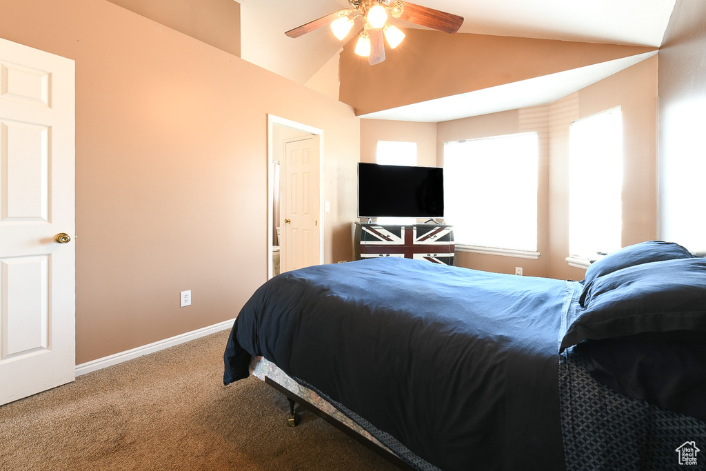 Bedroom featuring ceiling fan, vaulted ceiling, and carpet