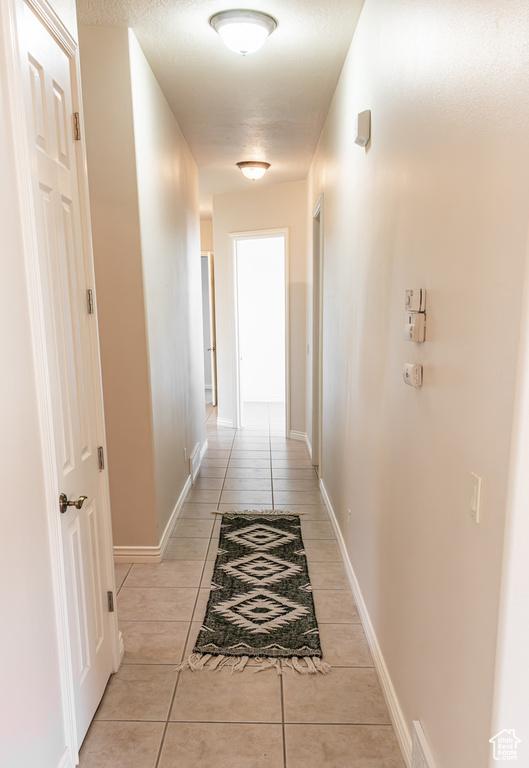 Corridor featuring light tile floors