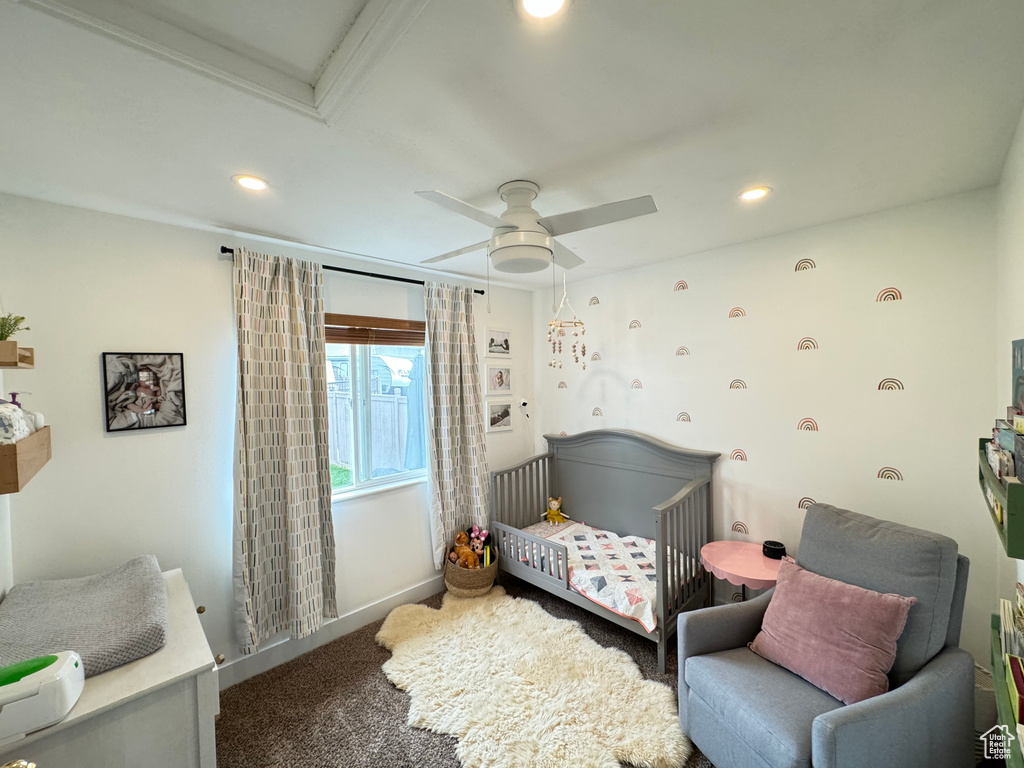 Bedroom featuring ceiling fan, carpet flooring, and a nursery area