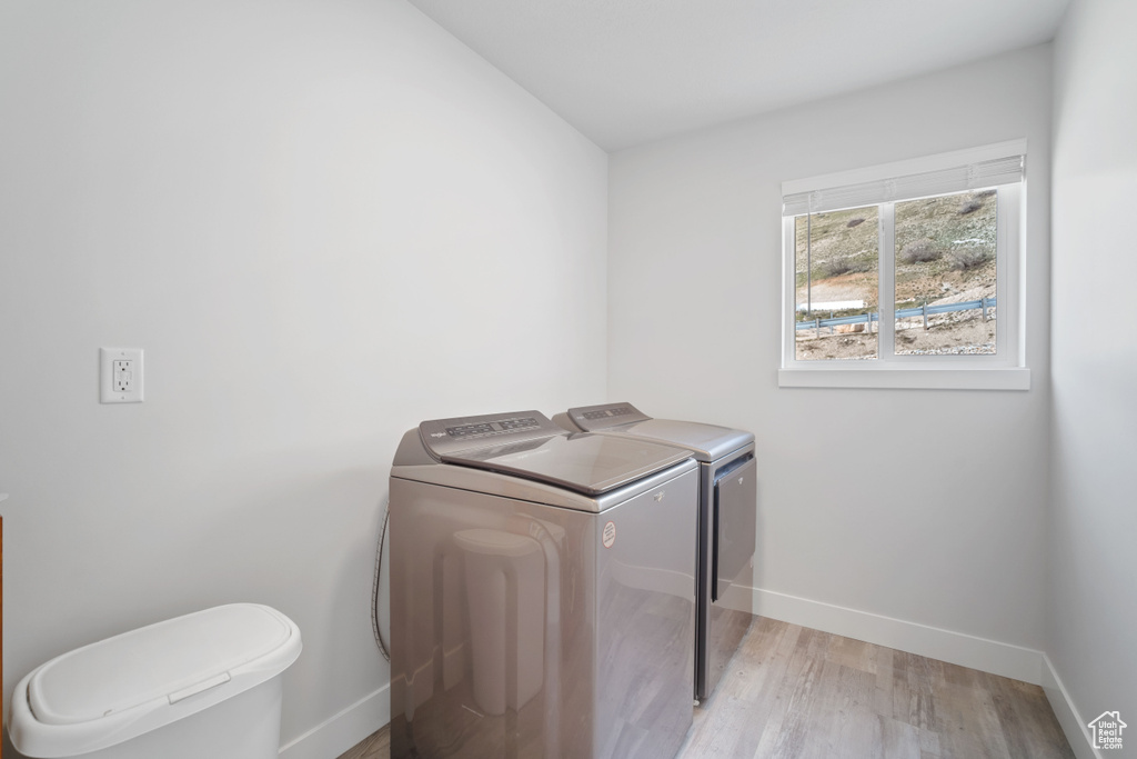 Laundry room with light hardwood / wood-style flooring and separate washer and dryer