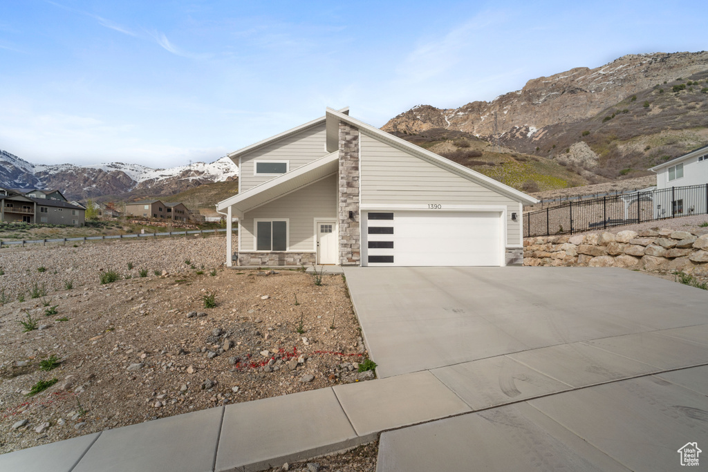 View of front of property with a garage and a mountain view