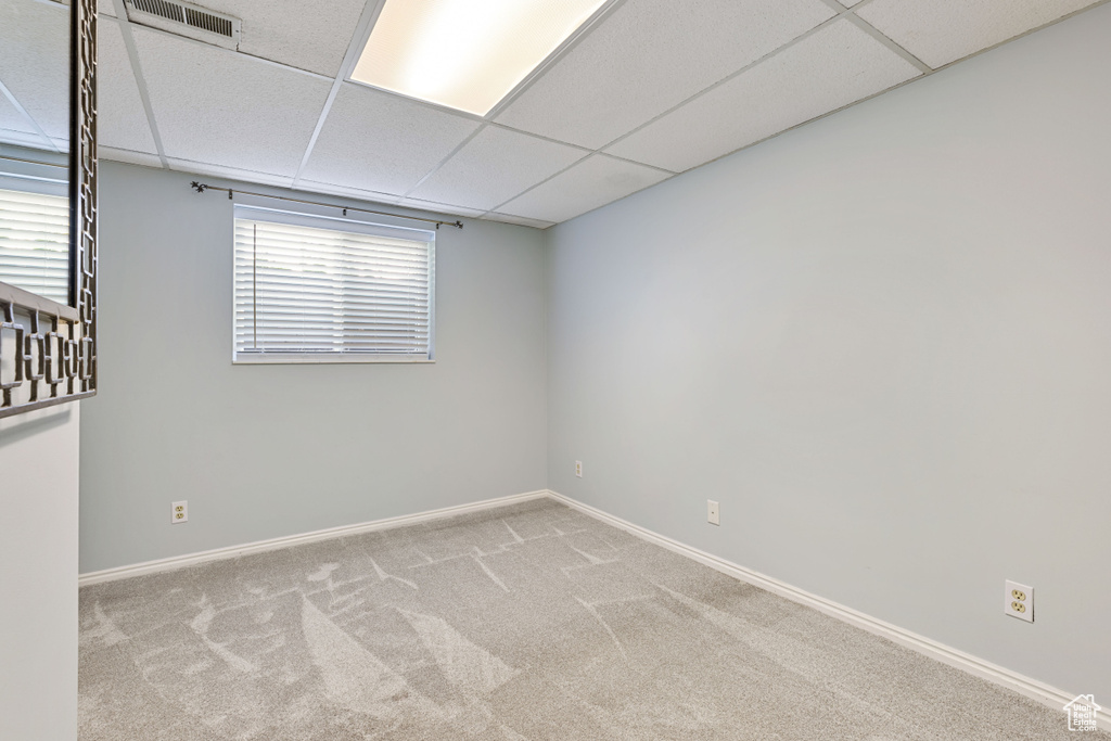 Unfurnished room featuring a paneled ceiling and carpet
