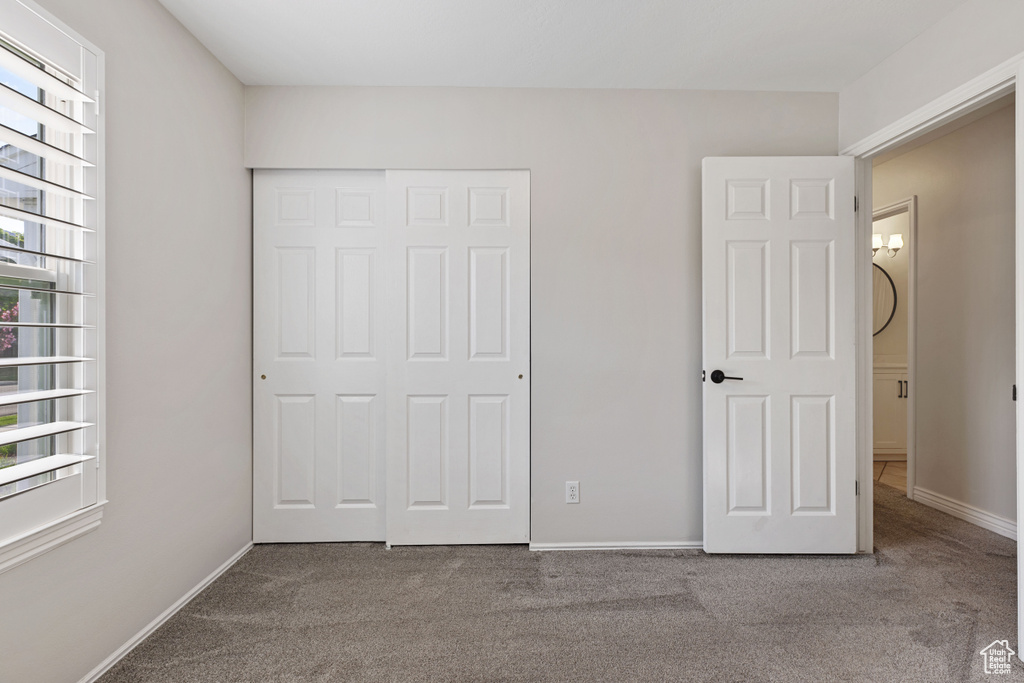 Unfurnished bedroom with a closet and carpet flooring
