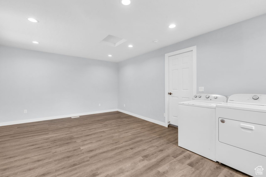 Laundry area with light hardwood / wood-style flooring and separate washer and dryer