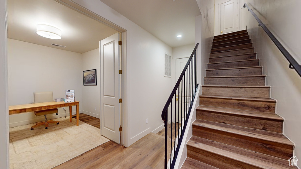 Stairs featuring hardwood / wood-style flooring