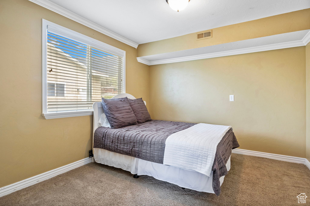 Bedroom featuring carpet and crown molding