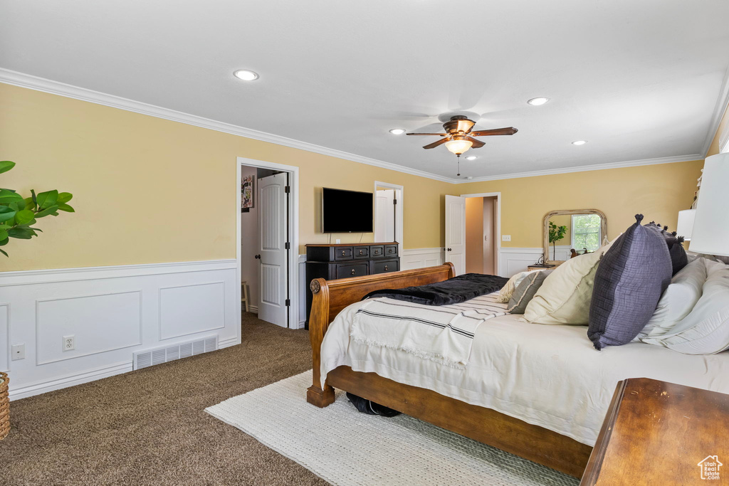 Bedroom featuring ceiling fan, carpet, a walk in closet, and ornamental molding