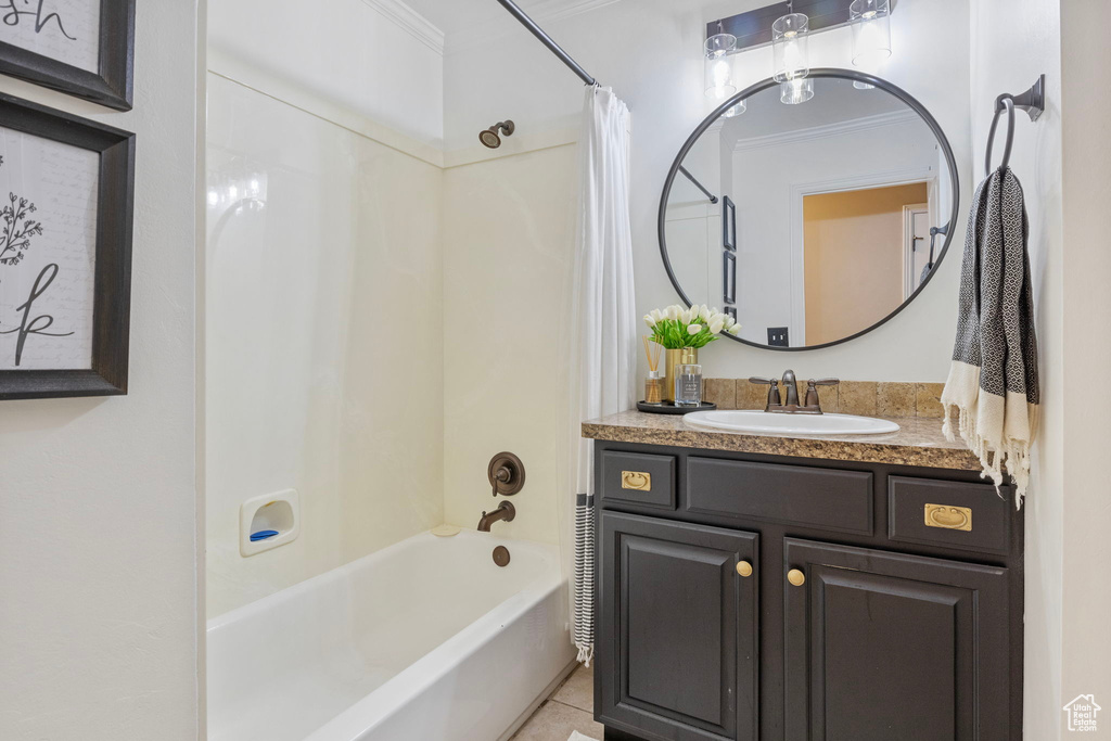 Bathroom with tile flooring, ornamental molding, vanity, and shower / bath combo
