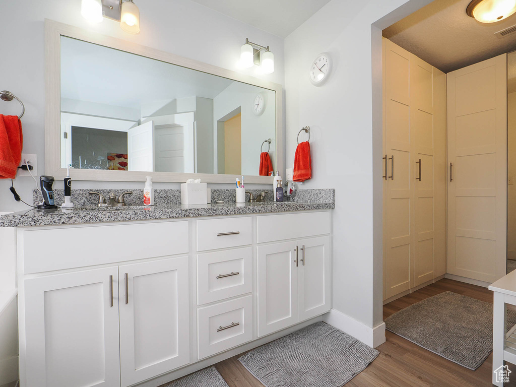 Bathroom featuring dual vanity and hardwood / wood-style floors