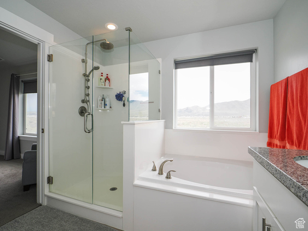 Bathroom with a mountain view, vanity, and separate shower and tub
