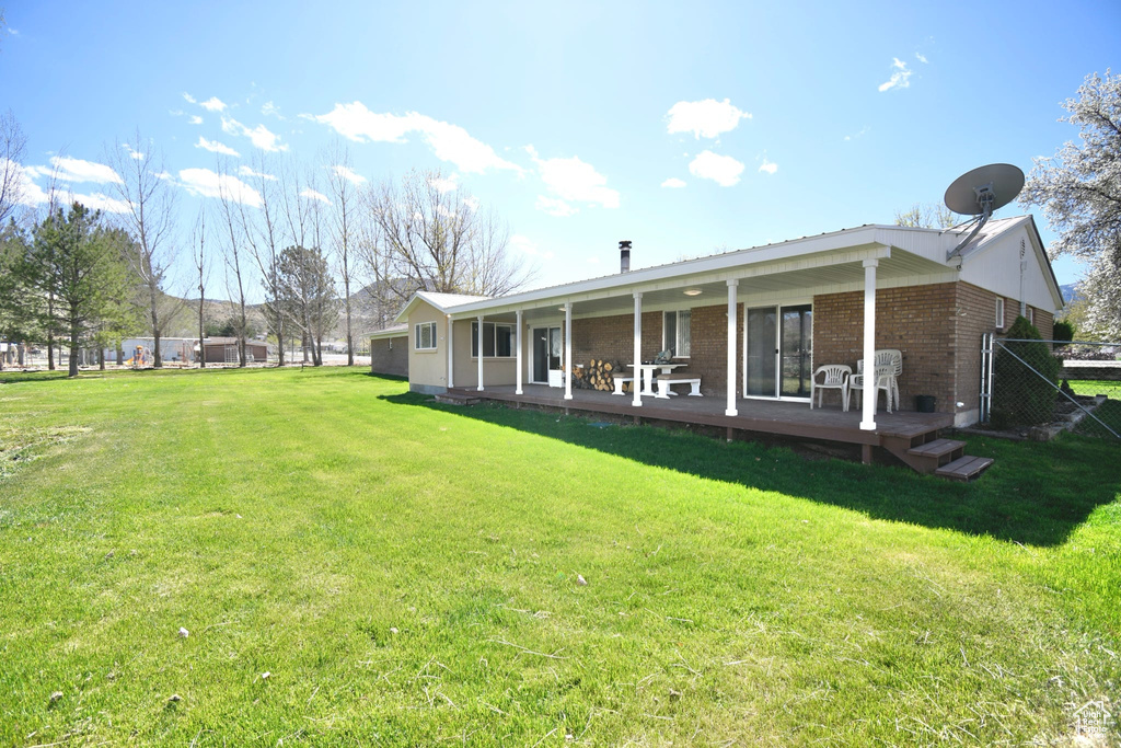 Rear view of property with a yard