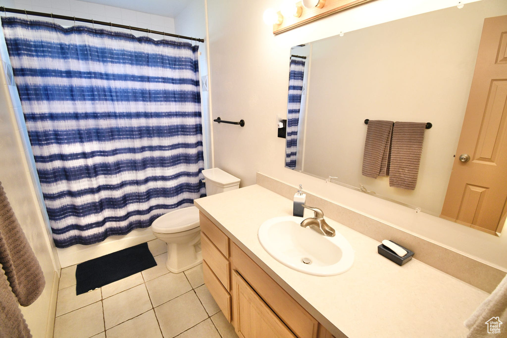 Bathroom featuring vanity, toilet, and tile floors