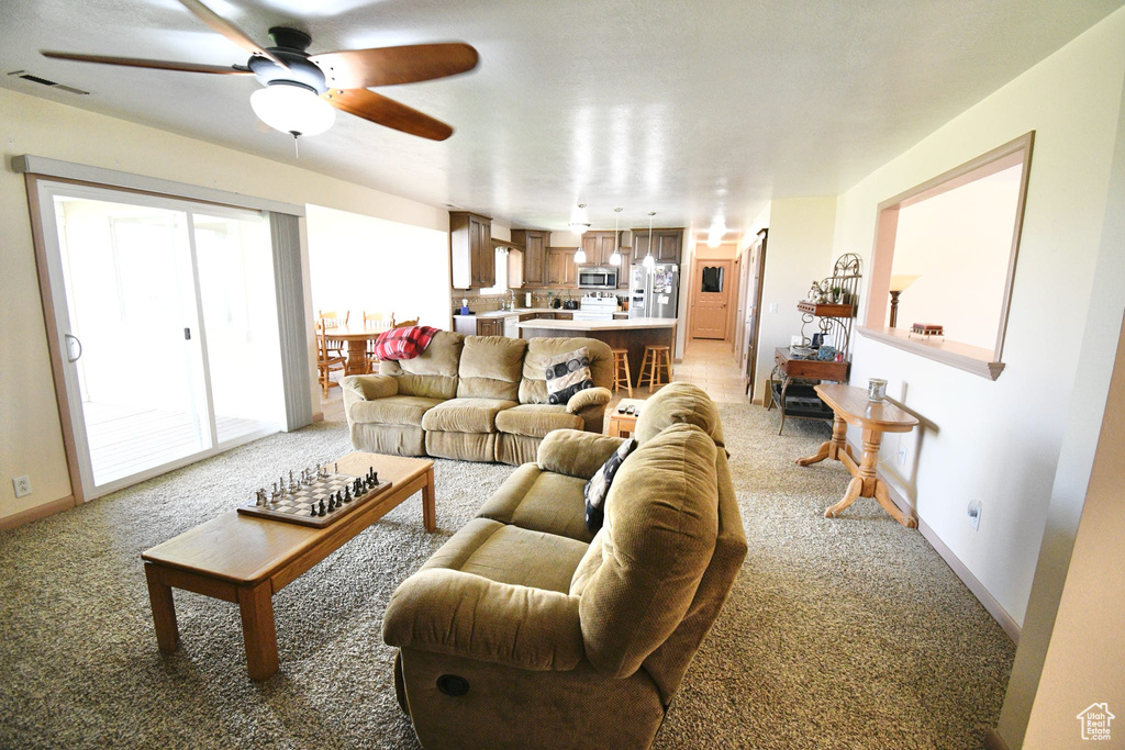 Carpeted living room with ceiling fan