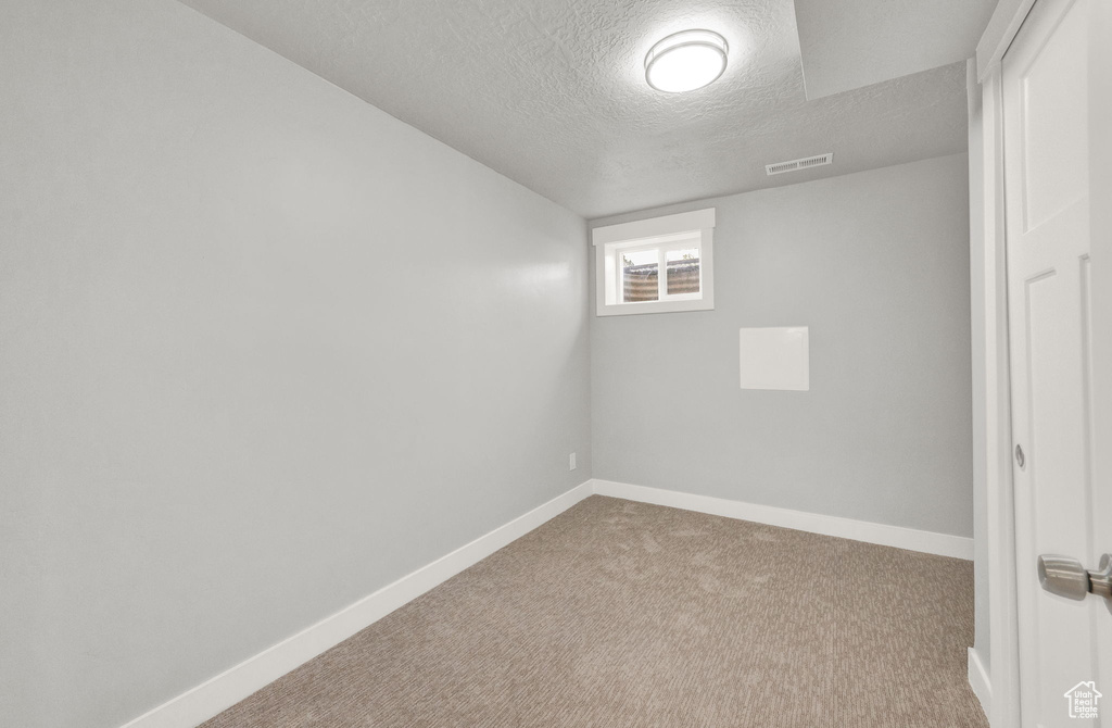 Spare room with carpet floors and a textured ceiling