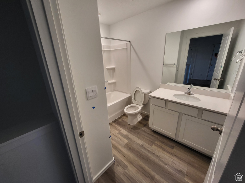 Full bathroom featuring shower / bathing tub combination, vanity, hardwood / wood-style flooring, and toilet