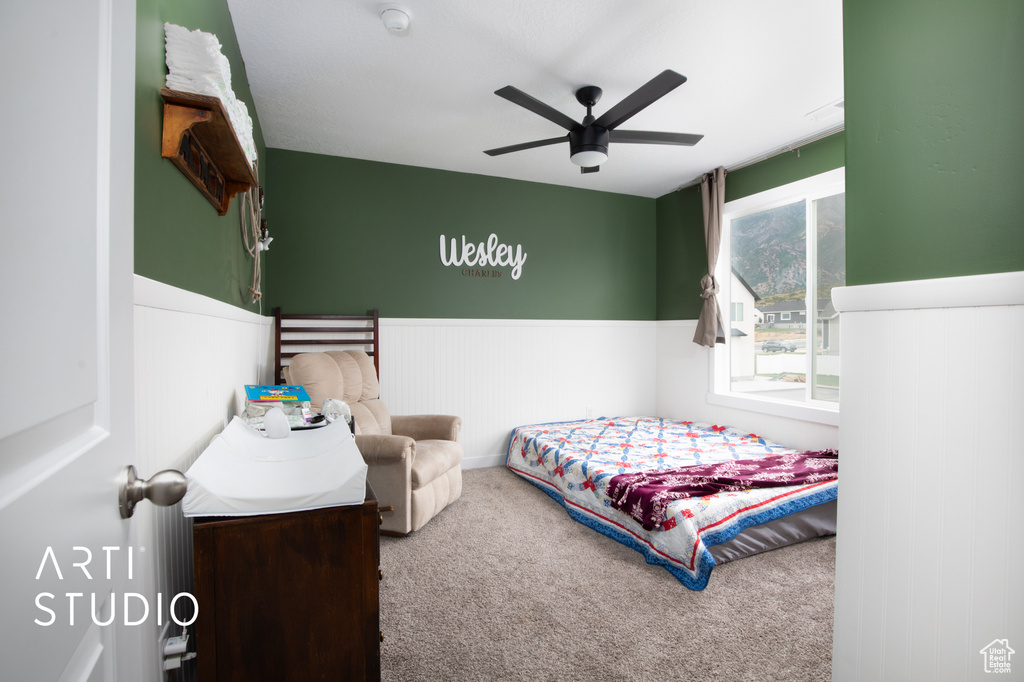 Carpeted bedroom featuring ceiling fan