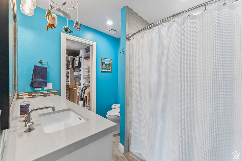Bathroom featuring vanity, hardwood / wood-style flooring, and toilet