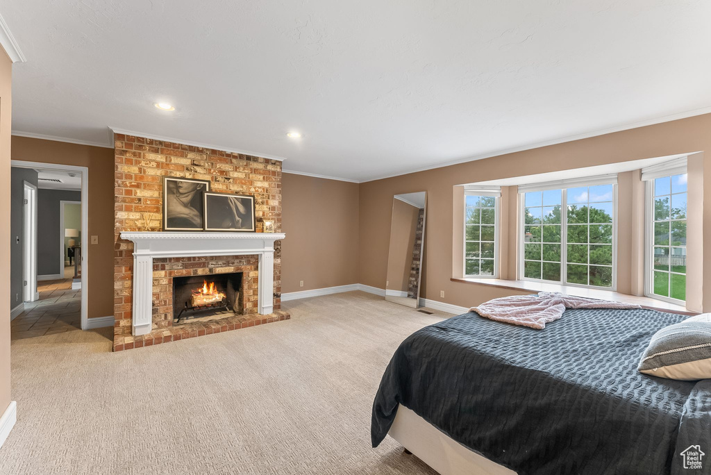 Carpeted bedroom featuring a fireplace and ornamental molding