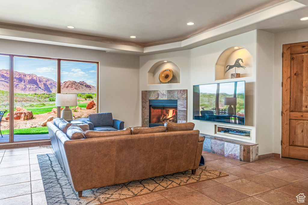 Tiled living room featuring a wealth of natural light, built in shelves, a mountain view, and a fireplace