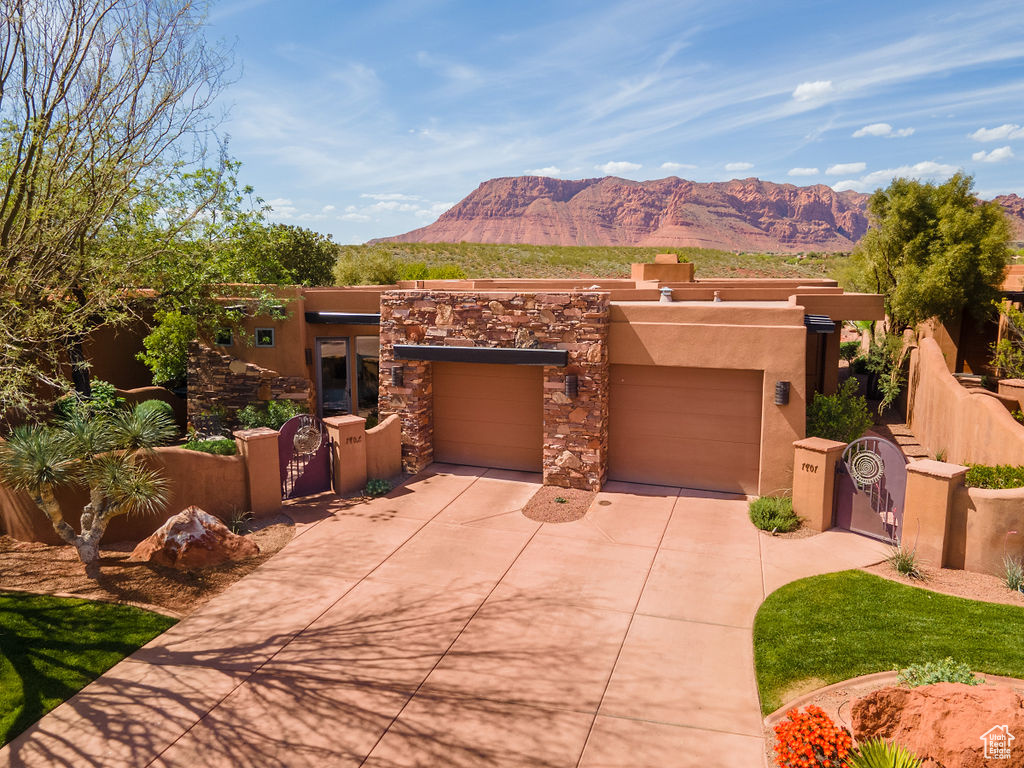 Southwest-style home with a mountain view, area for grilling, and a garage