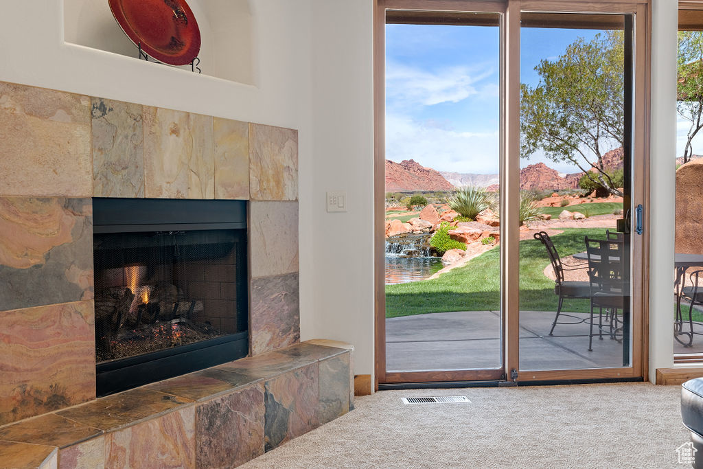 Doorway to outside with a tile fireplace and carpet