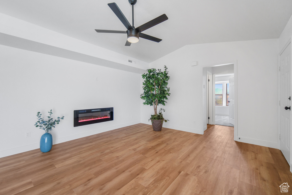 Unfurnished room with light hardwood / wood-style floors, ceiling fan, and lofted ceiling