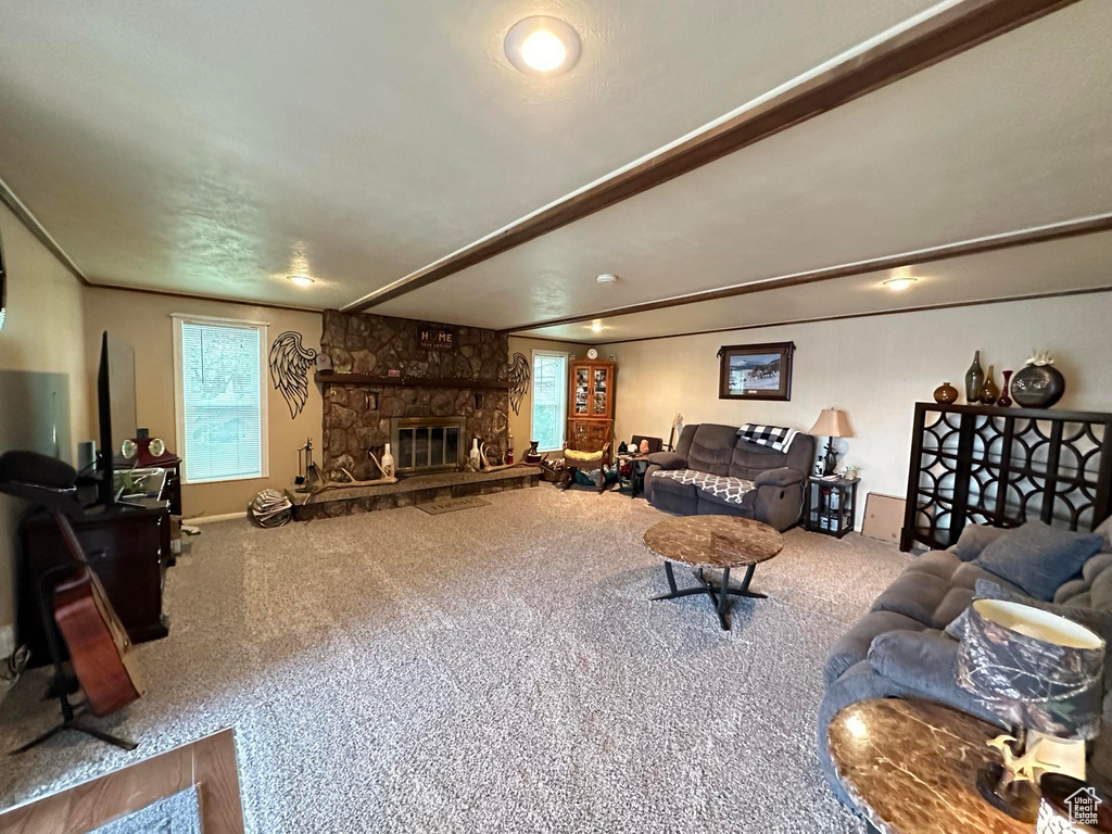 Carpeted living room with a stone fireplace
