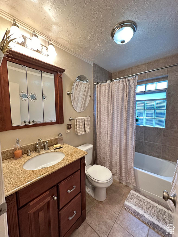 Full bathroom with tile flooring, a textured ceiling, shower / bath combination with curtain, toilet, and vanity