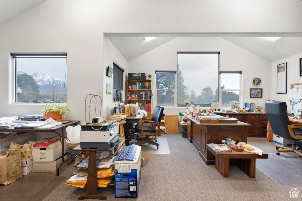 Home office with light carpet and vaulted ceiling