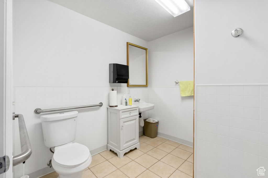 Bathroom with tile walls, vanity, tile floors, and toilet