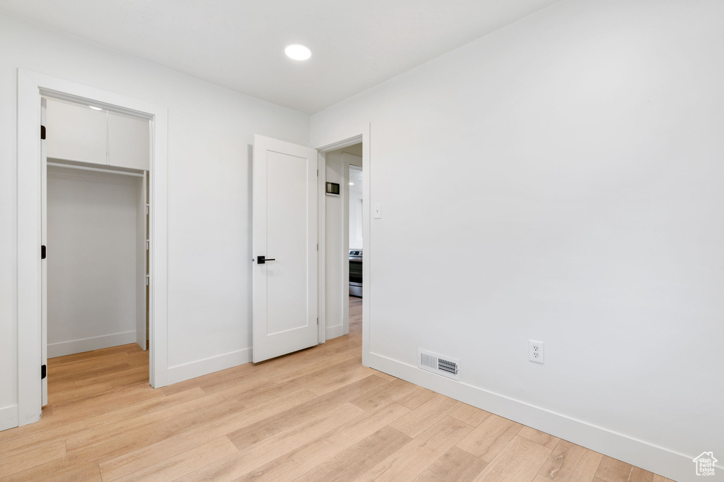 Unfurnished bedroom featuring light hardwood / wood-style floors and a closet