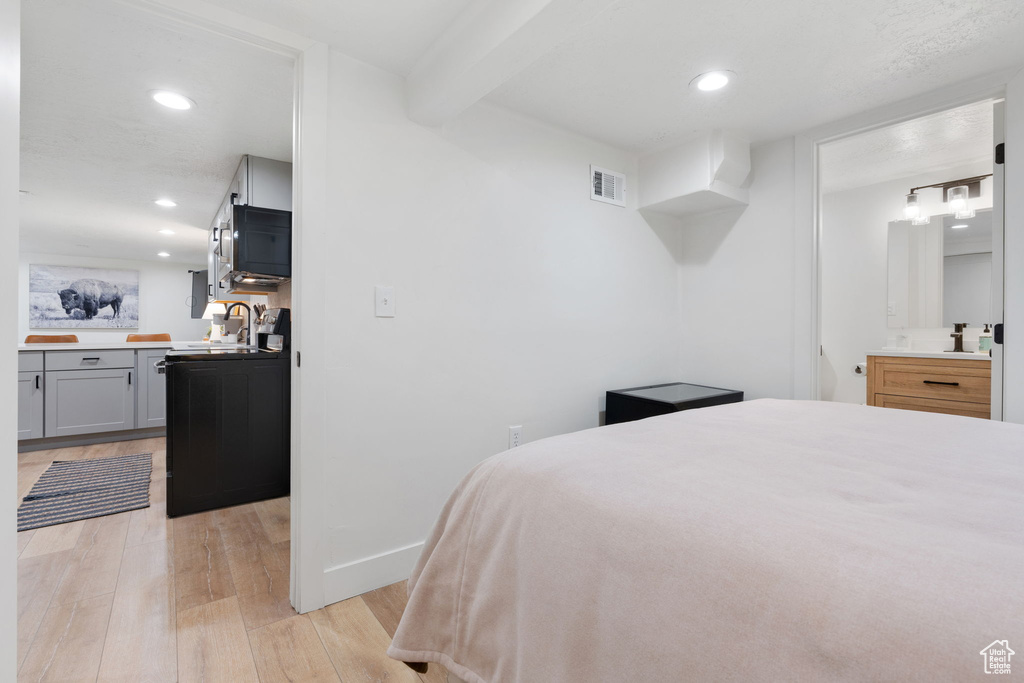 Bedroom featuring beamed ceiling and light wood-type flooring