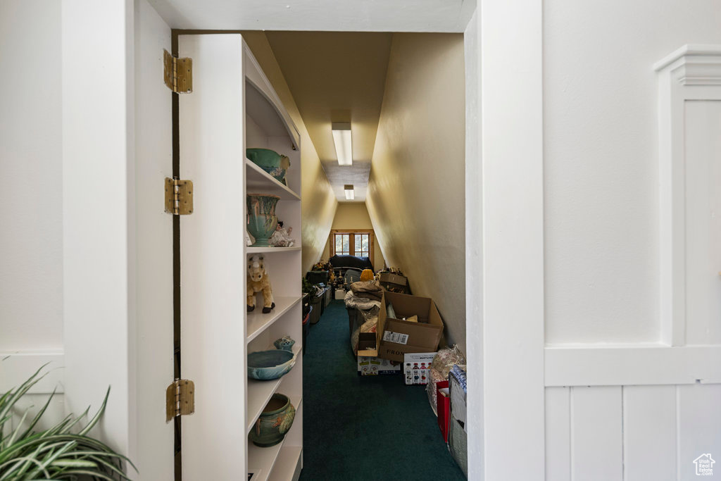 Corridor with carpet flooring and lofted ceiling