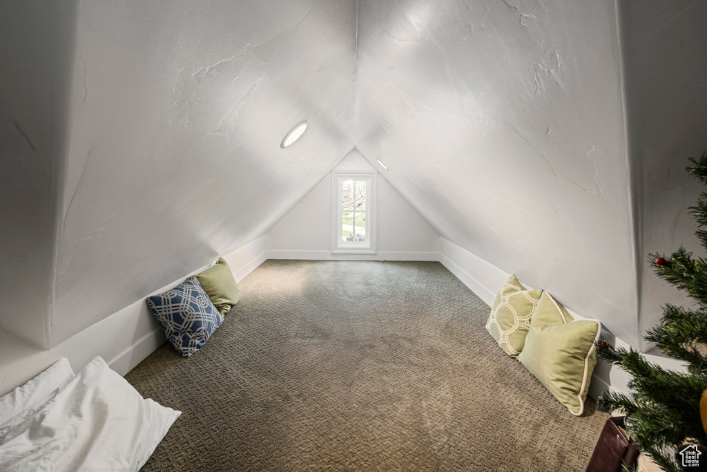 Bonus room featuring vaulted ceiling and carpet flooring