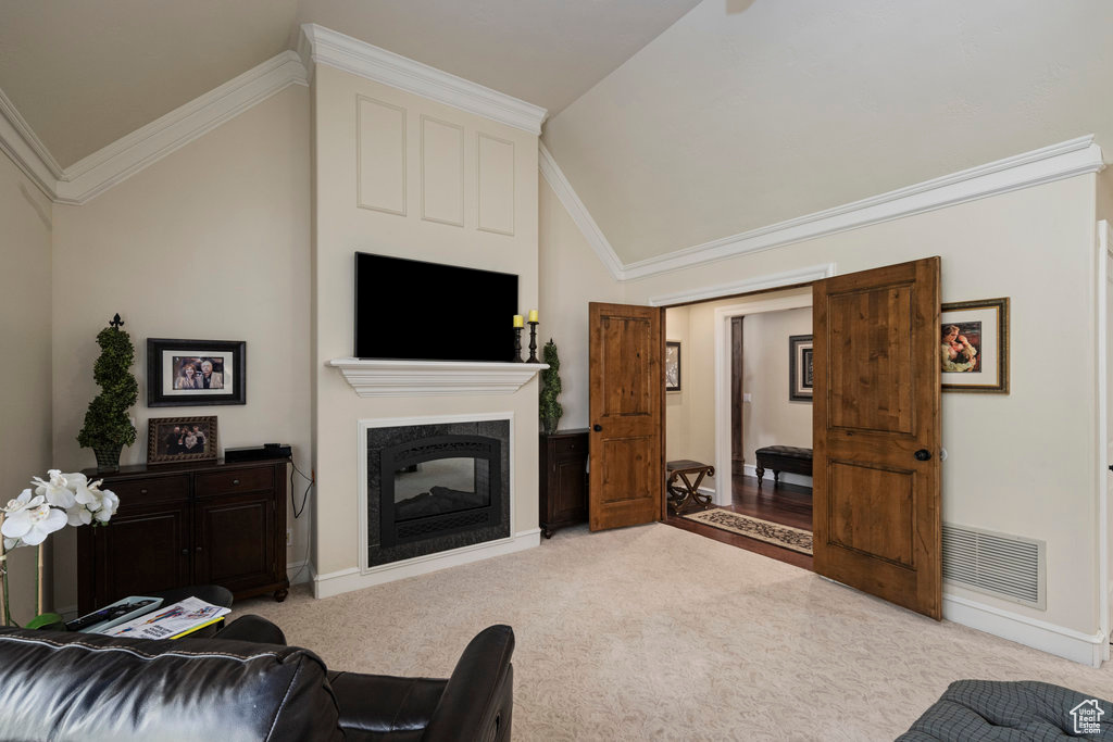 Carpeted living room featuring ornamental molding, a multi sided fireplace, and high vaulted ceiling