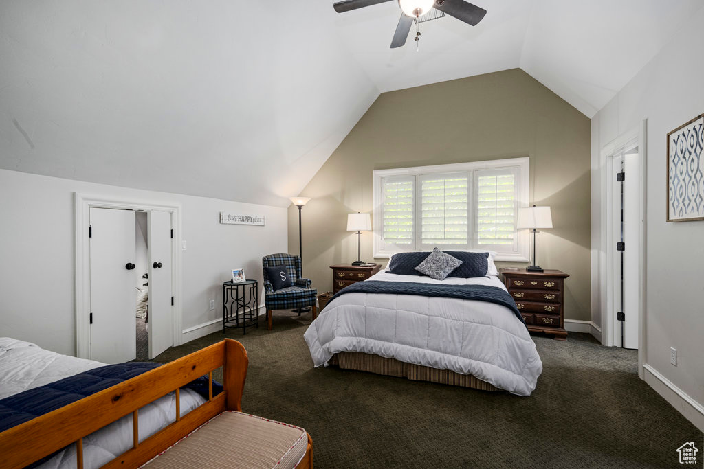 Bedroom with vaulted ceiling, ceiling fan, and dark colored carpet