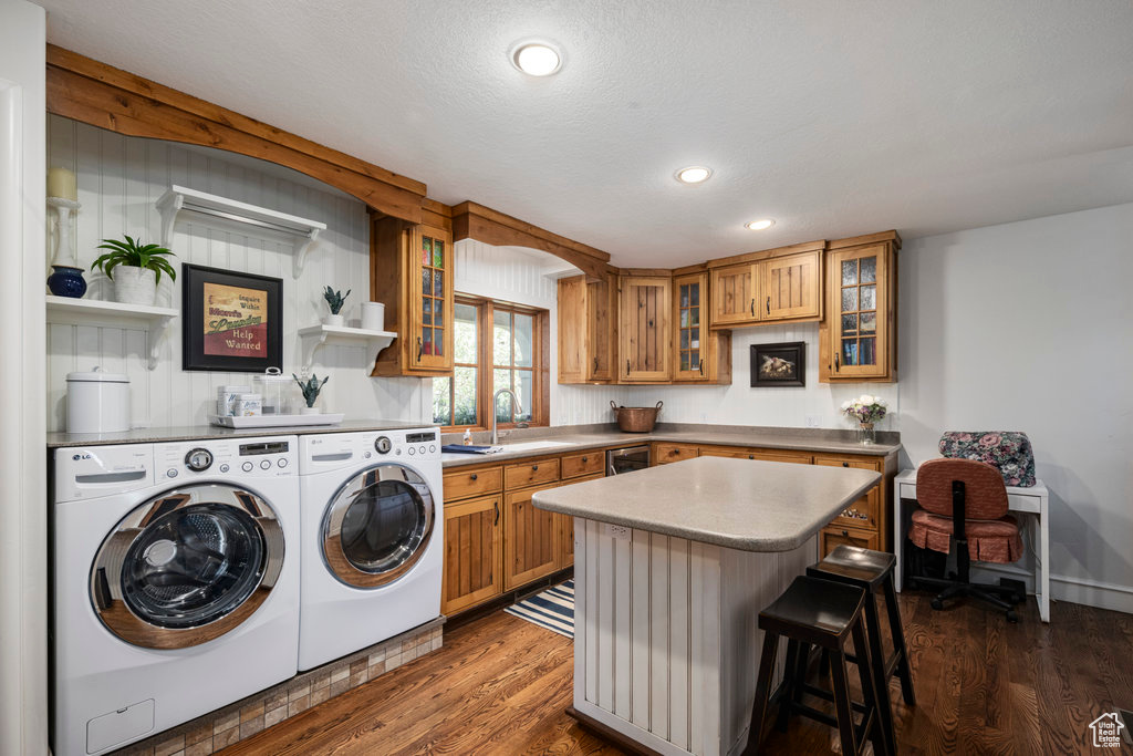Washroom with independent washer and dryer, dark hardwood / wood-style flooring, and sink