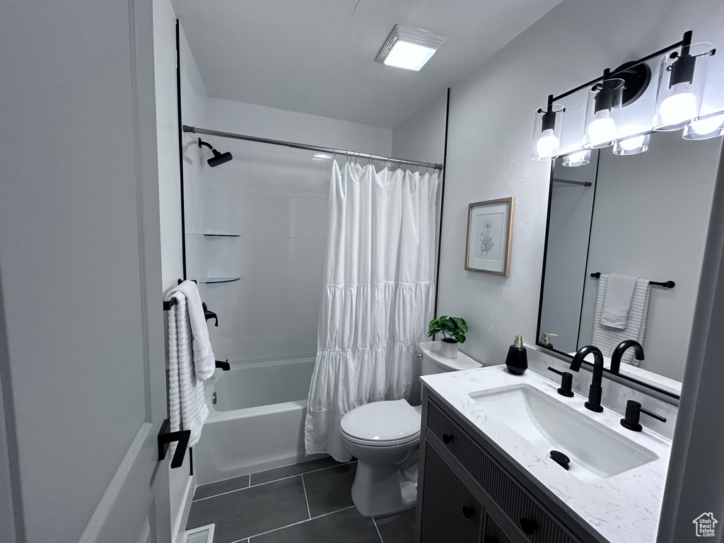 Full bathroom featuring tile flooring, vanity, toilet, and shower / bathtub combination with curtain