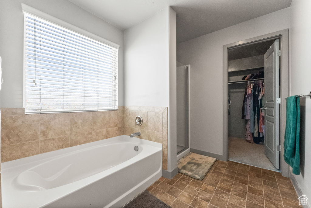 Bathroom with plenty of natural light, separate shower and tub, and tile floors