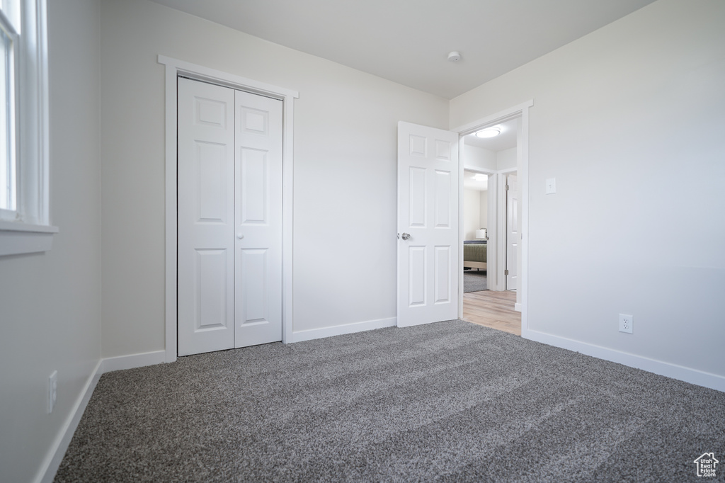 Unfurnished bedroom with a closet and carpet