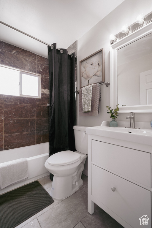 Full bathroom with oversized vanity, toilet, tile floors, and shower / bath combo with shower curtain
