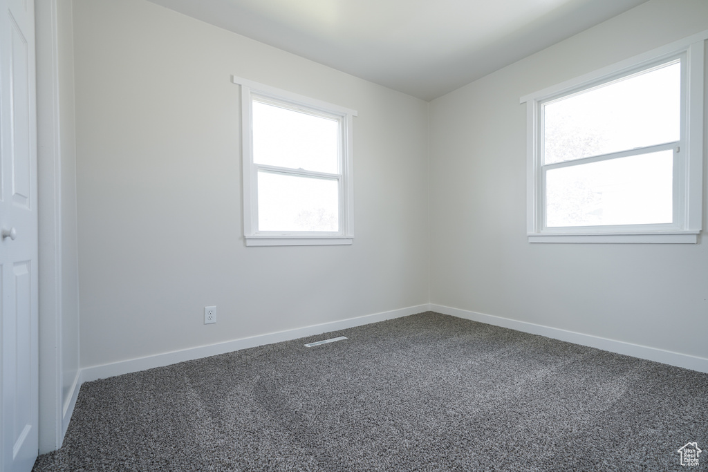 Spare room with a healthy amount of sunlight and carpet flooring