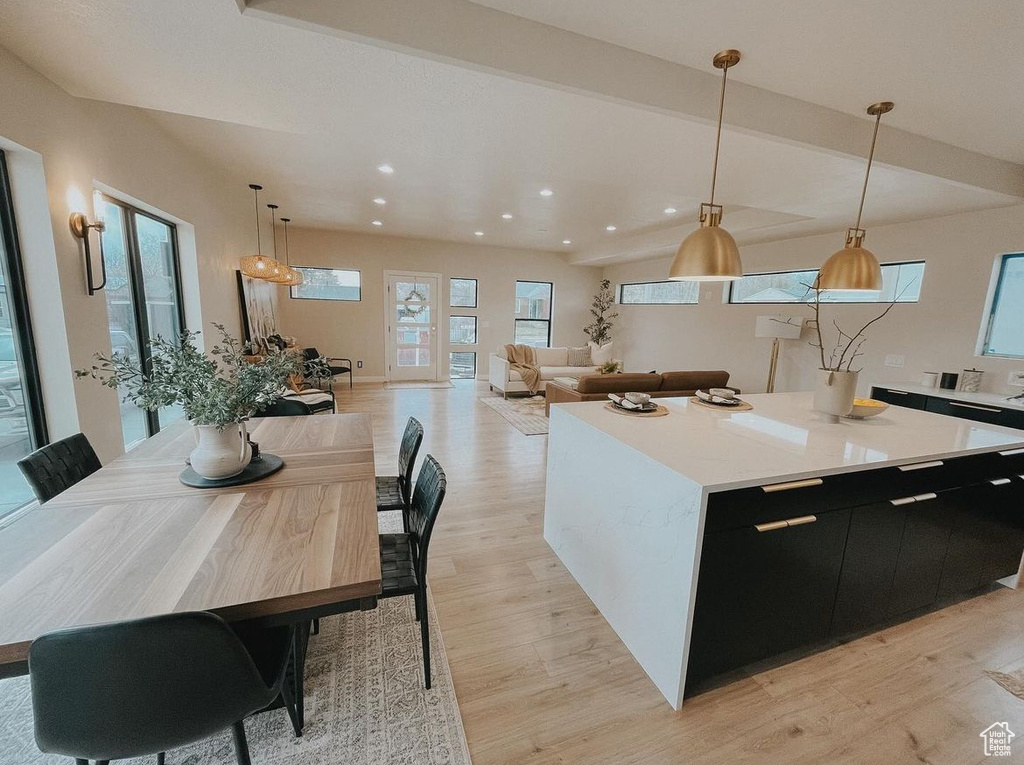 Kitchen with a center island, plenty of natural light, light hardwood / wood-style flooring, and decorative light fixtures