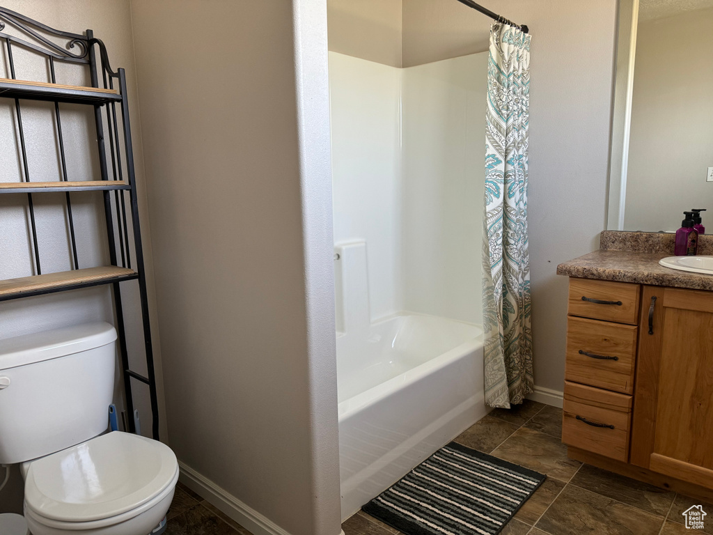 Full bathroom featuring tile flooring, vanity, shower / bath combo, and toilet