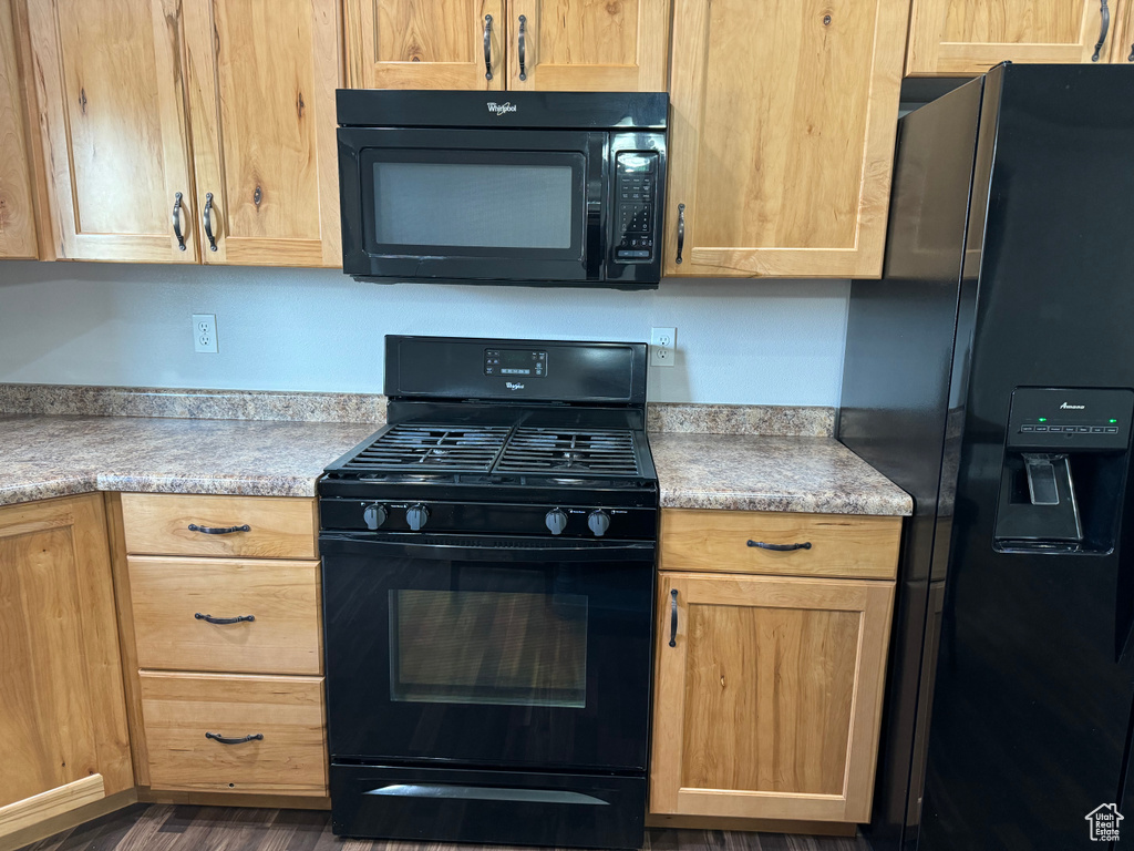 Kitchen with black appliances and dark wood-type flooring