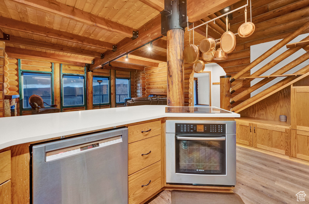 Kitchen featuring light hardwood / wood-style flooring, wooden ceiling, appliances with stainless steel finishes, log walls, and beam ceiling